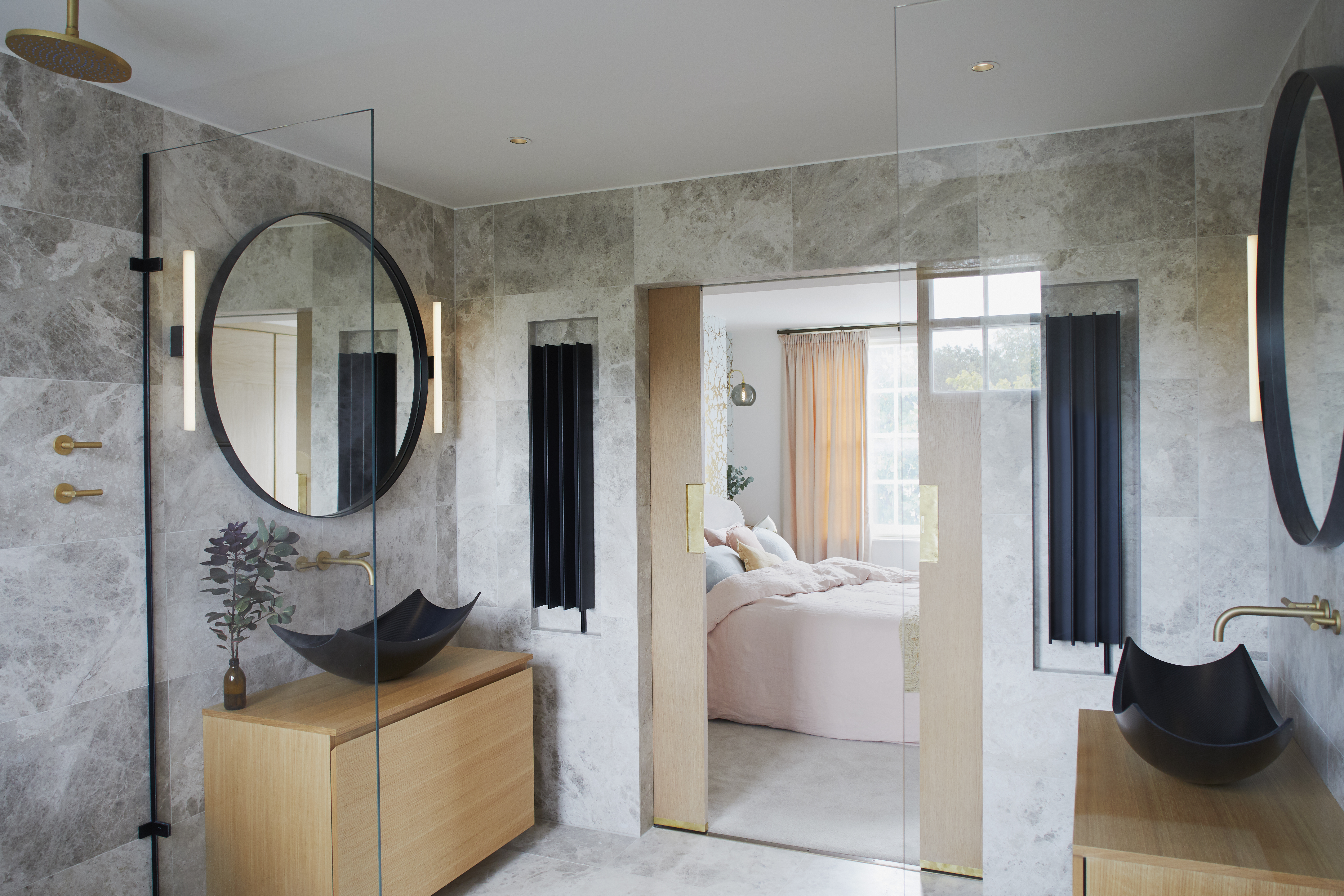 black basin sinks in en suite bathroom with marble walls