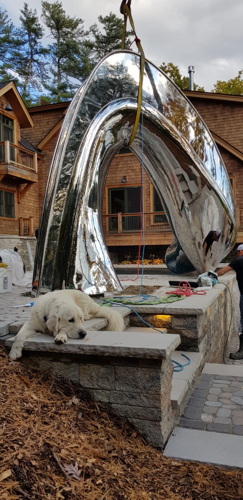 Outdoor family pool slide being installed at lake-house with dog