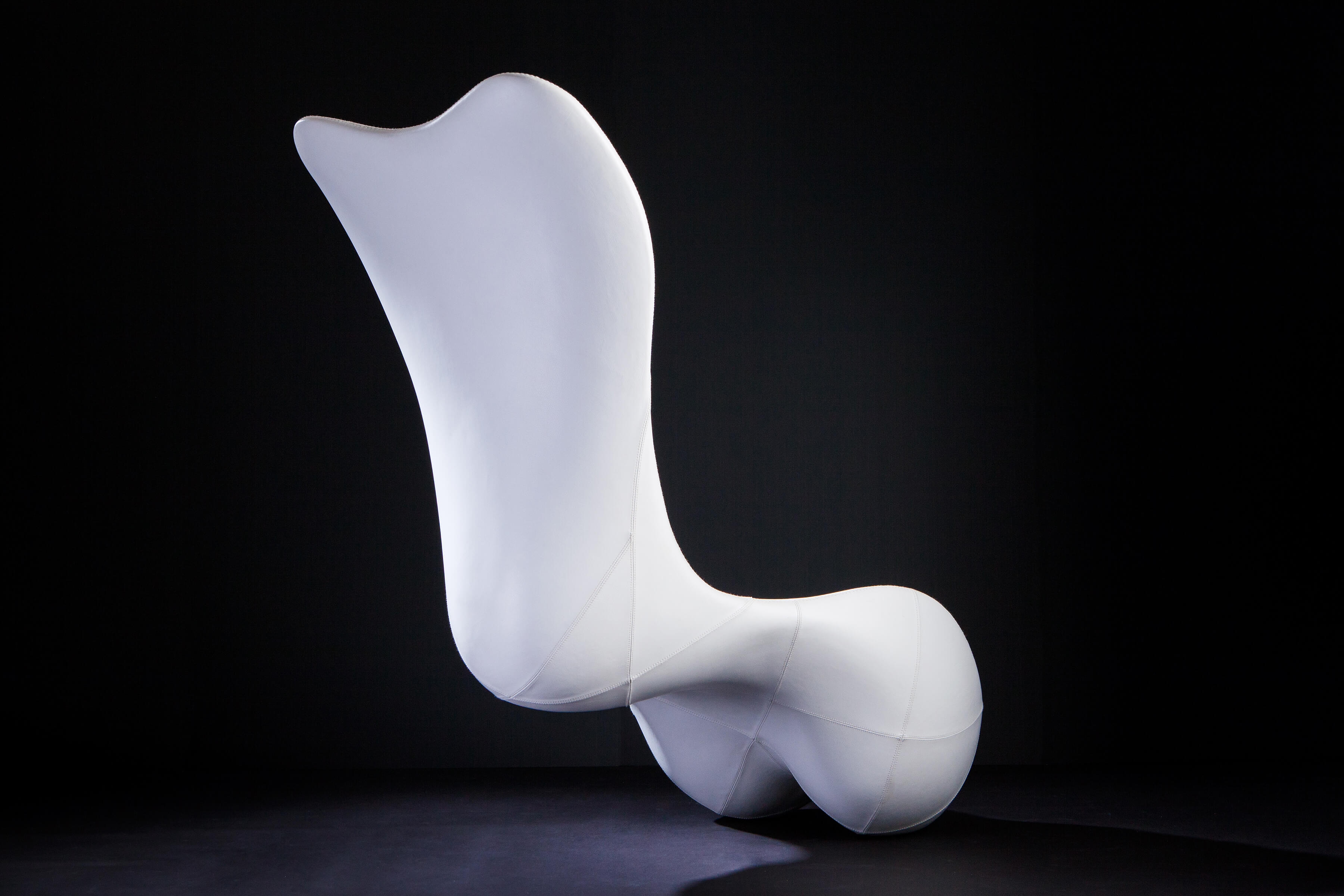 Back view of sculptural custom lounge chair in white leather.