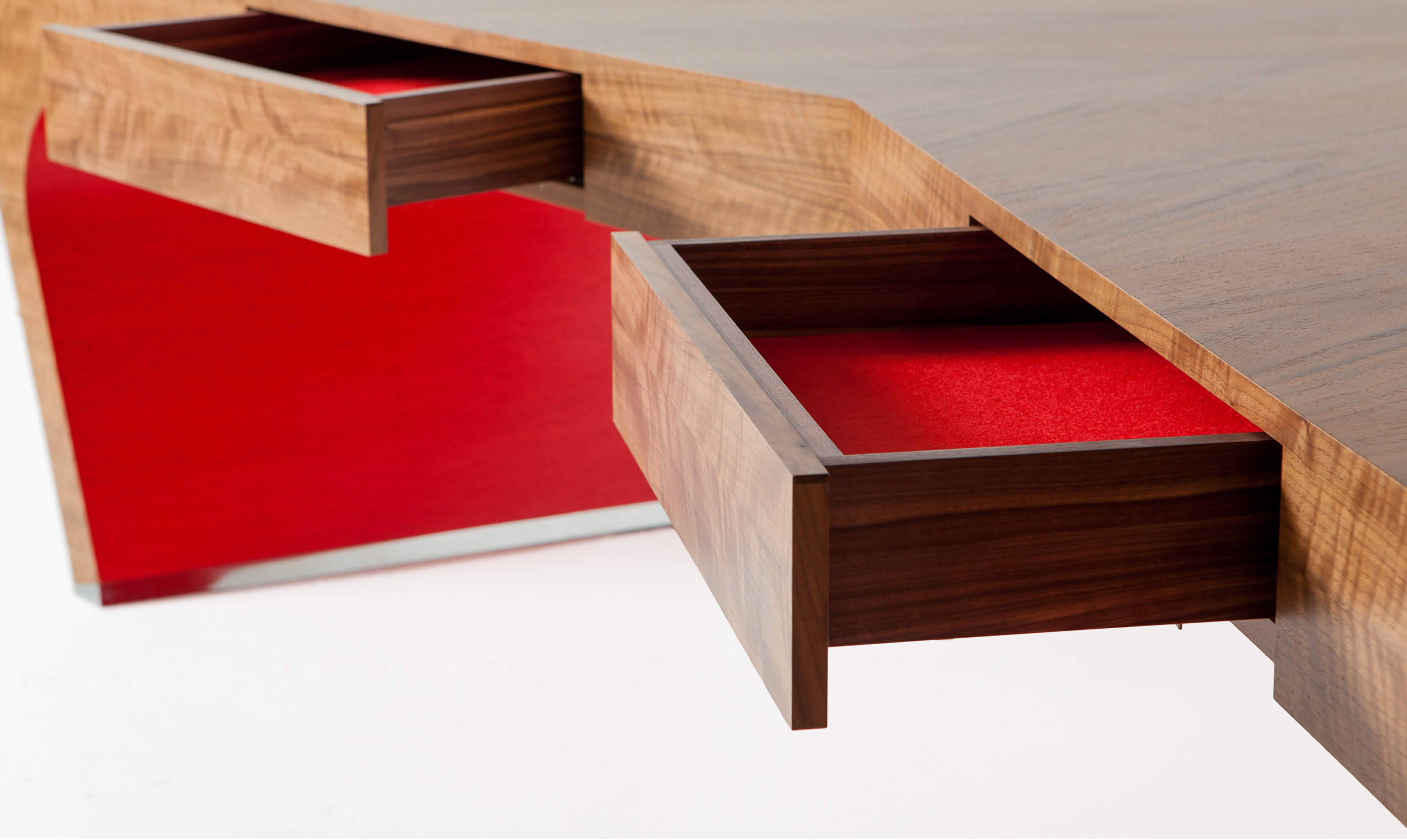 Red detail on empowering hand-crafted desk in v-shaped design