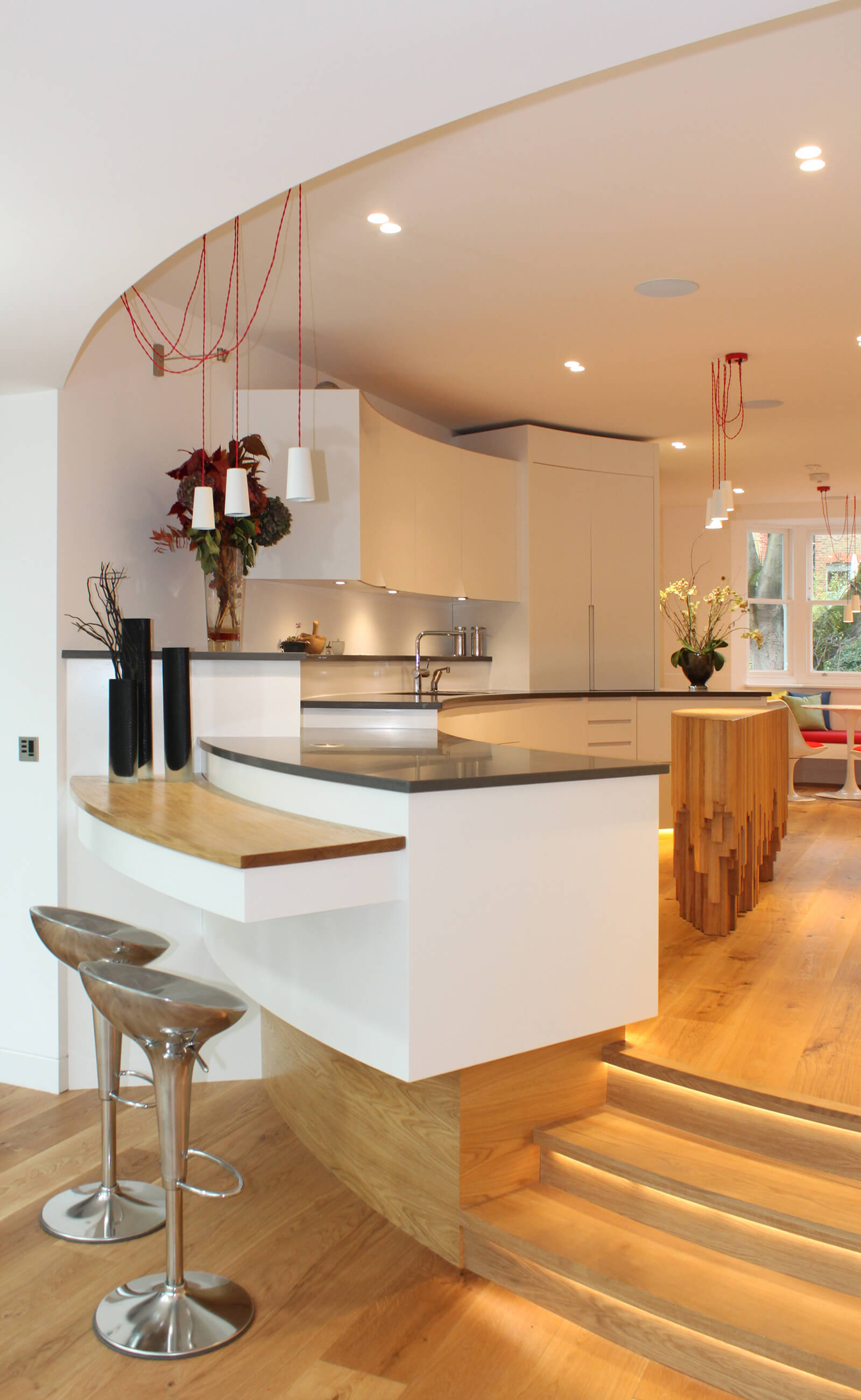 Modern kitchen design over a split level with sculptural kitchen island.