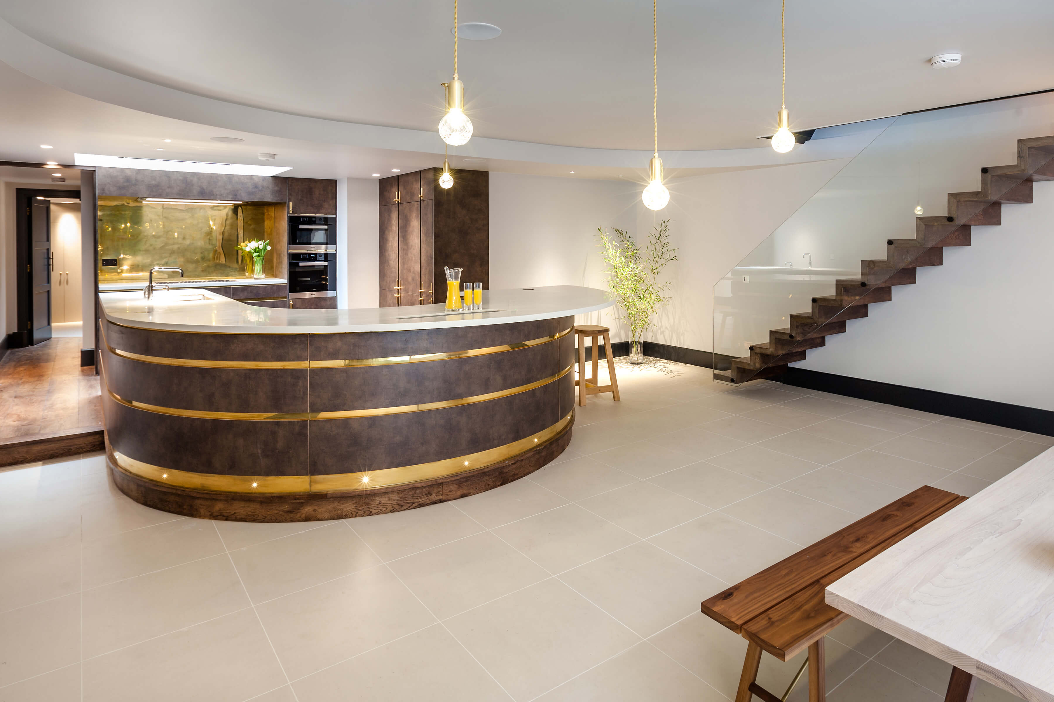 Basement kitchen with dark kitchen cabinetry and brass detail