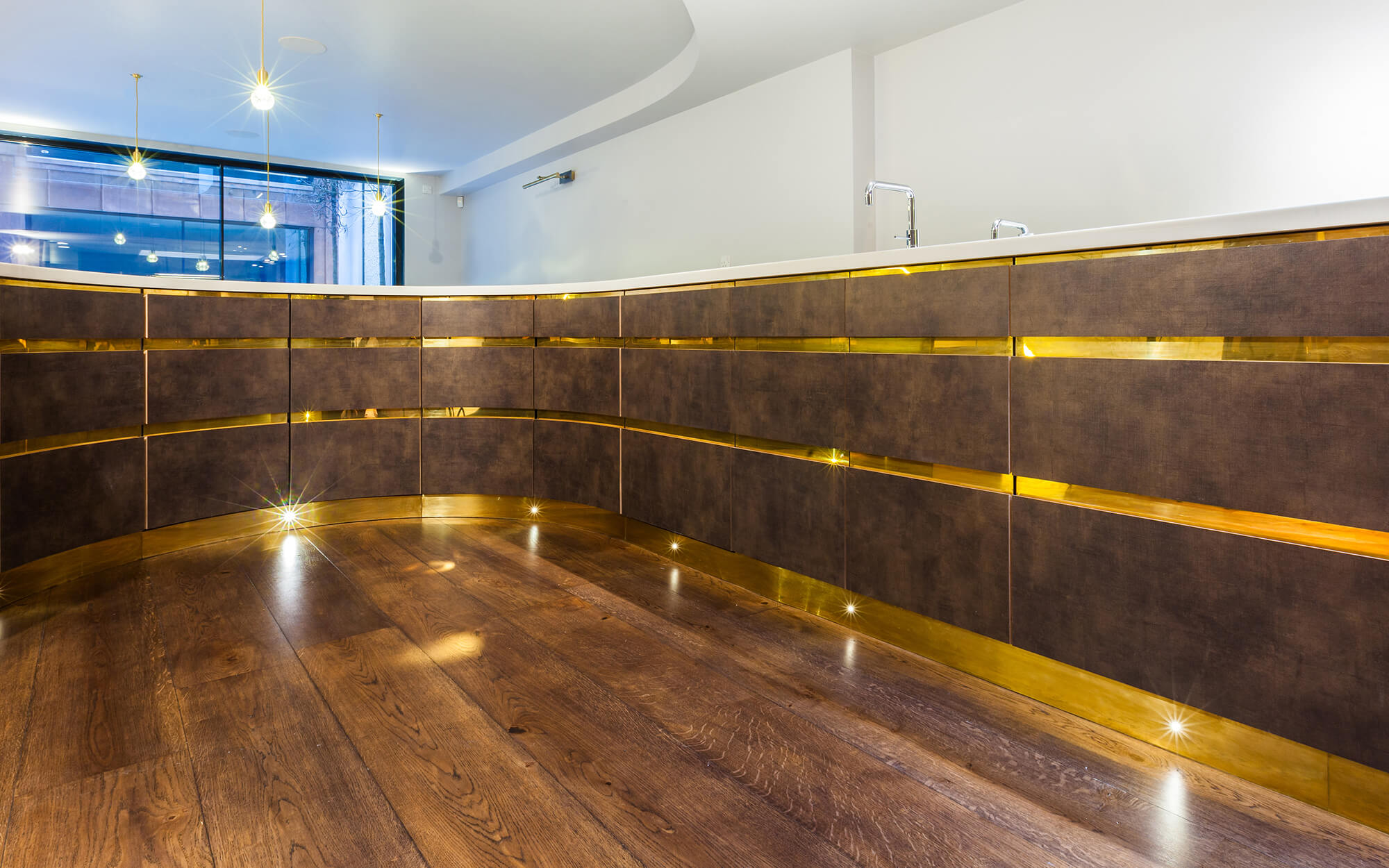 Clever hidden storage in luxury kitchen with brass details and brass kick-board