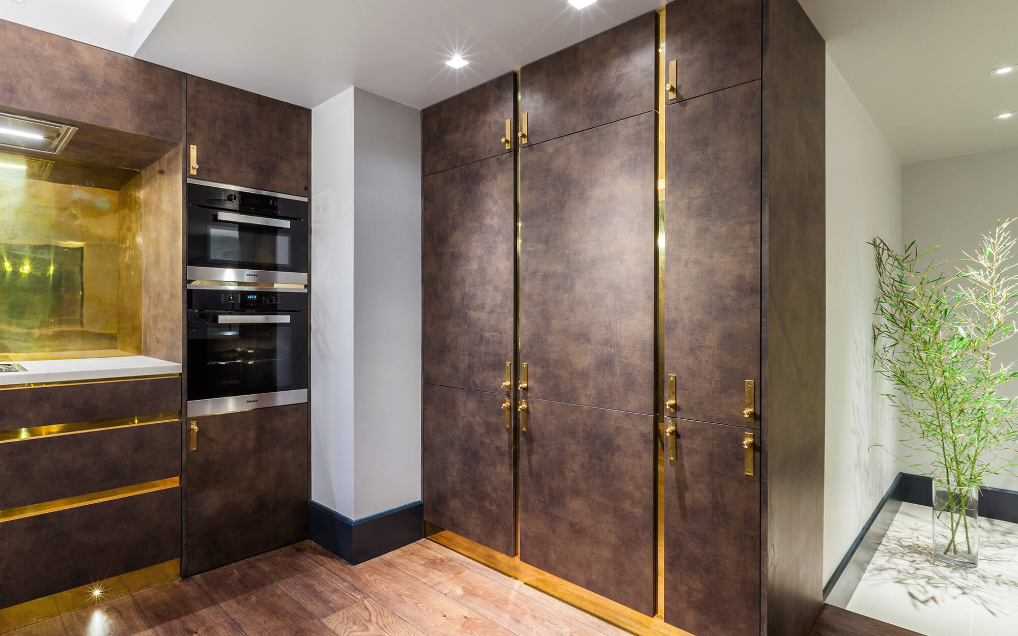 Dark kitchen cabinetry with brass detail and clever storage