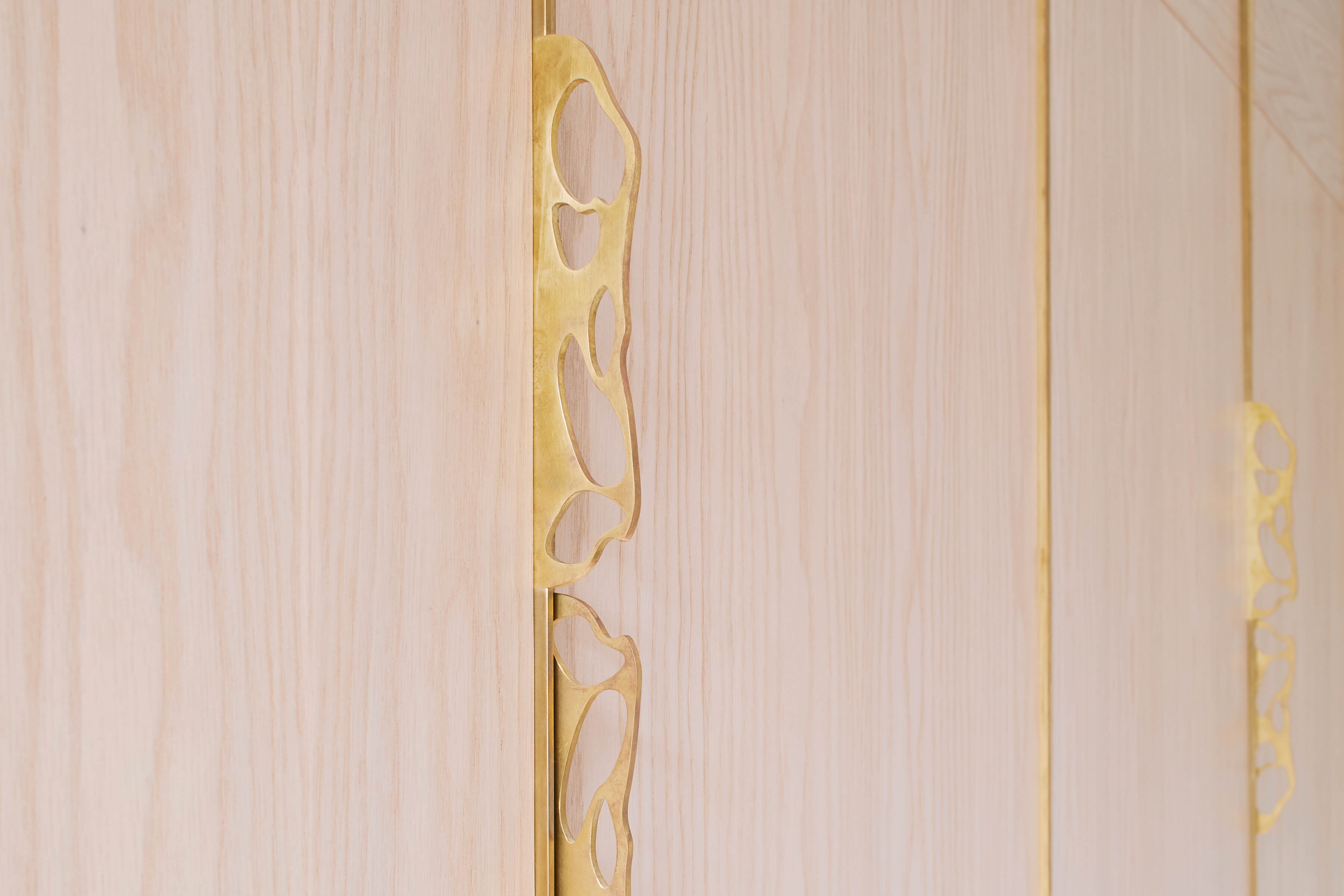 Detail of delicate bedroom cabinetry with sculpted brass handles custom made by Splinterworks