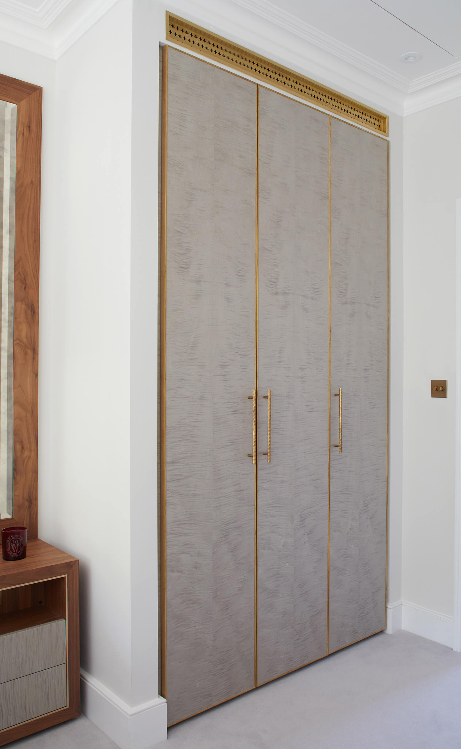 Custom built in wardrobes in sycamore with brass details in a calm serene bedroom