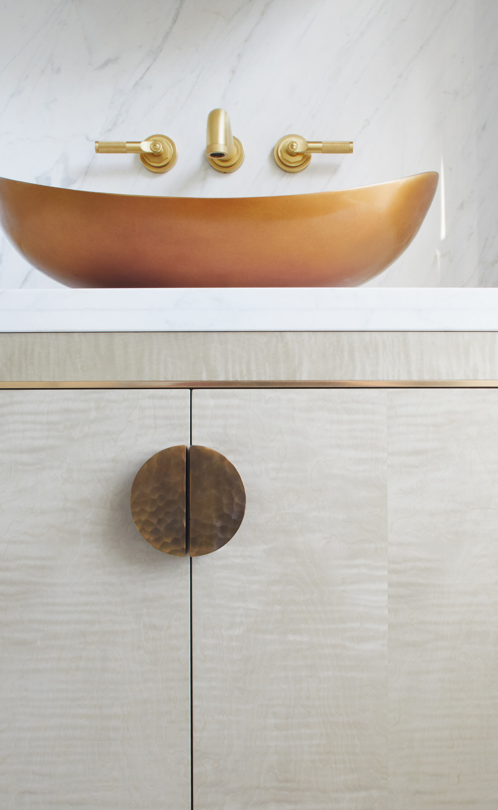 brass basin on veneered bathroom vanity cabinet by Splinterworks in carrara marble bathroom