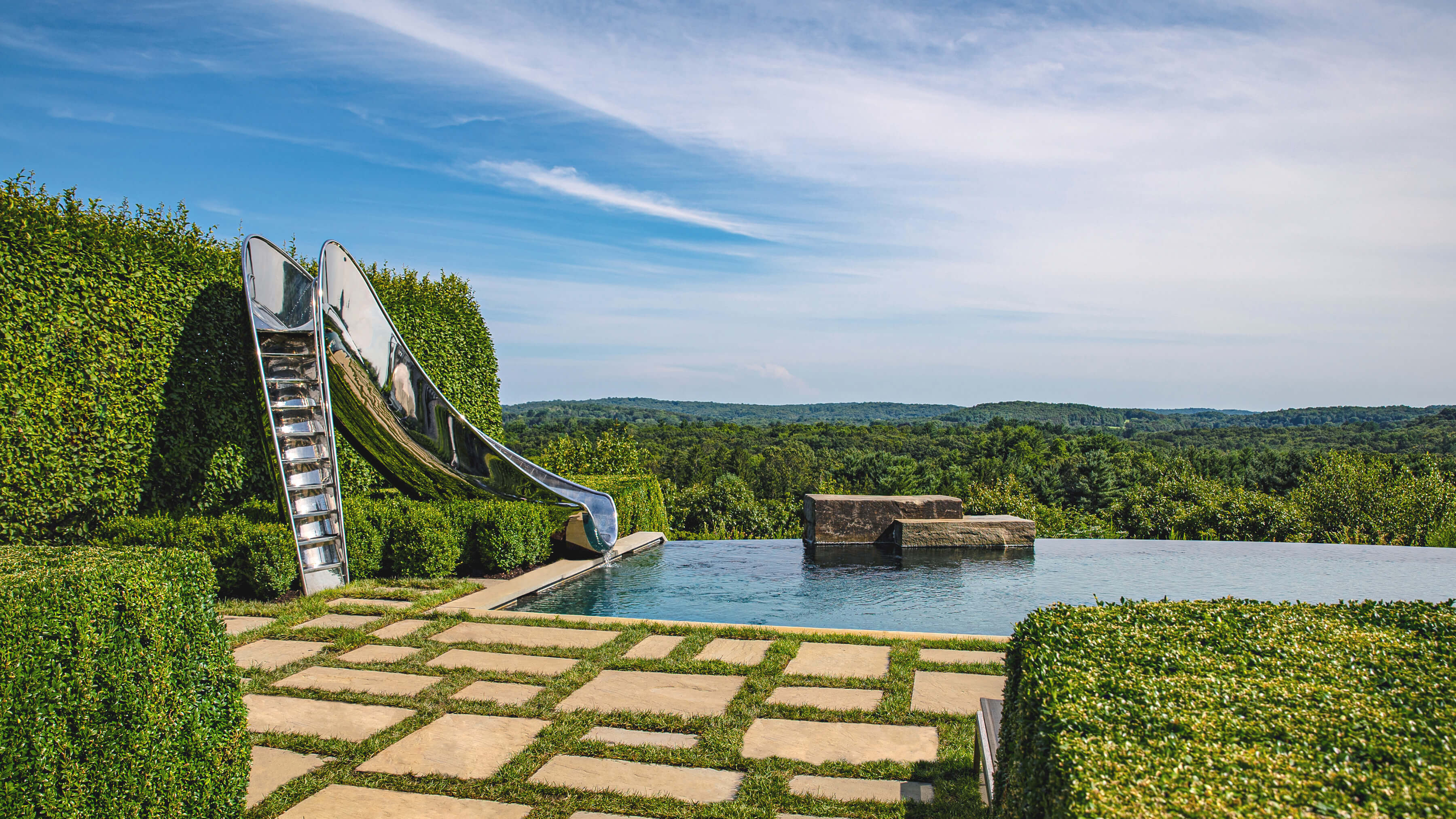 Luxury water slide next to beautiful infinity pool in up state New York.