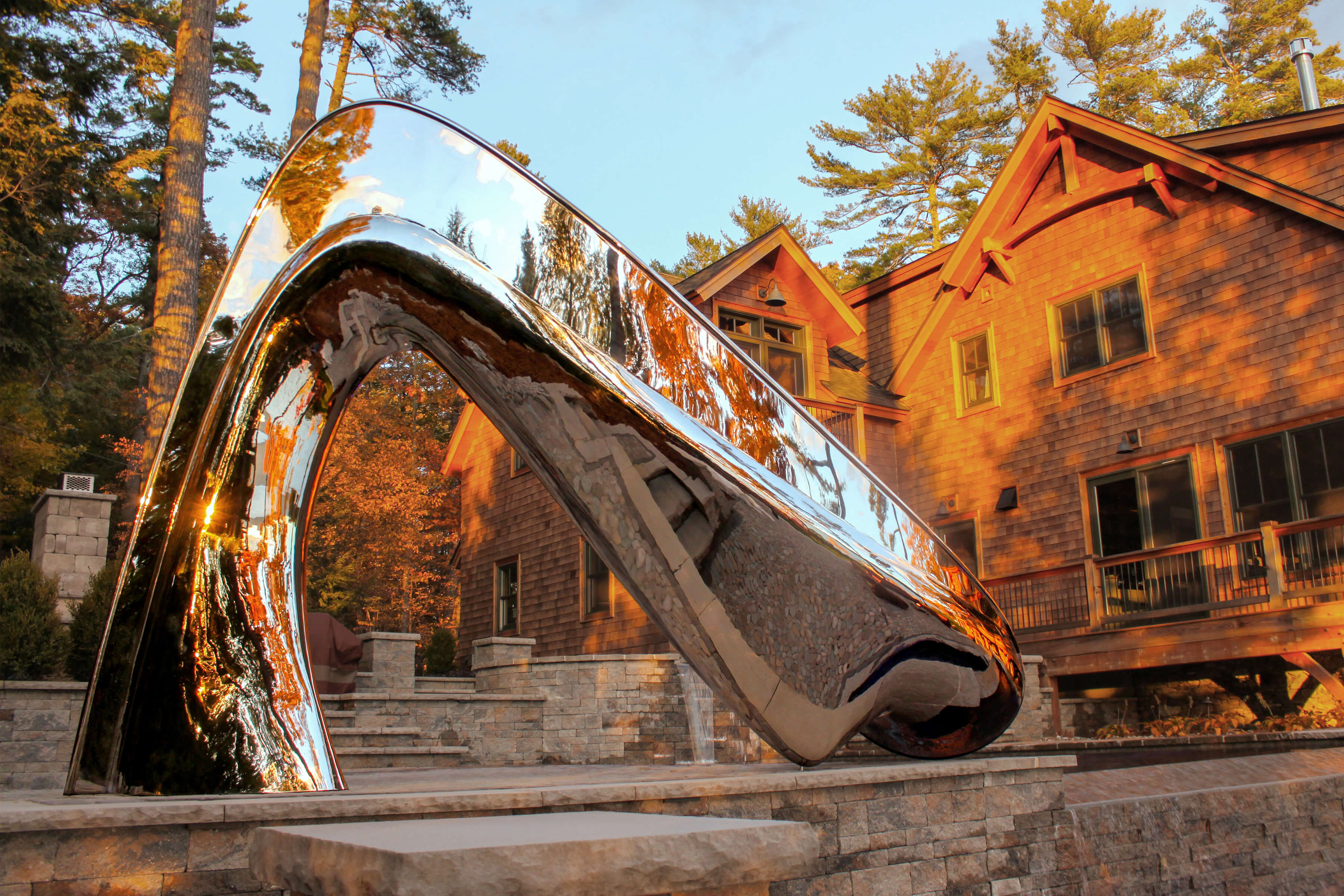 The Vertex pool slide by Splinterworks at sunset with the wooden house.