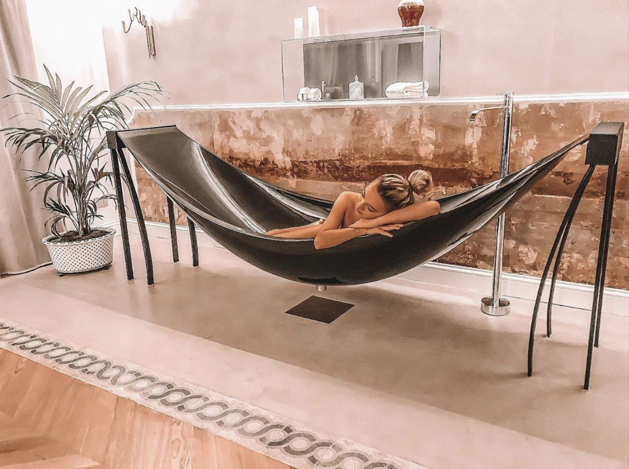 Woman in black suspended bath in luxurious hotel in Rome.