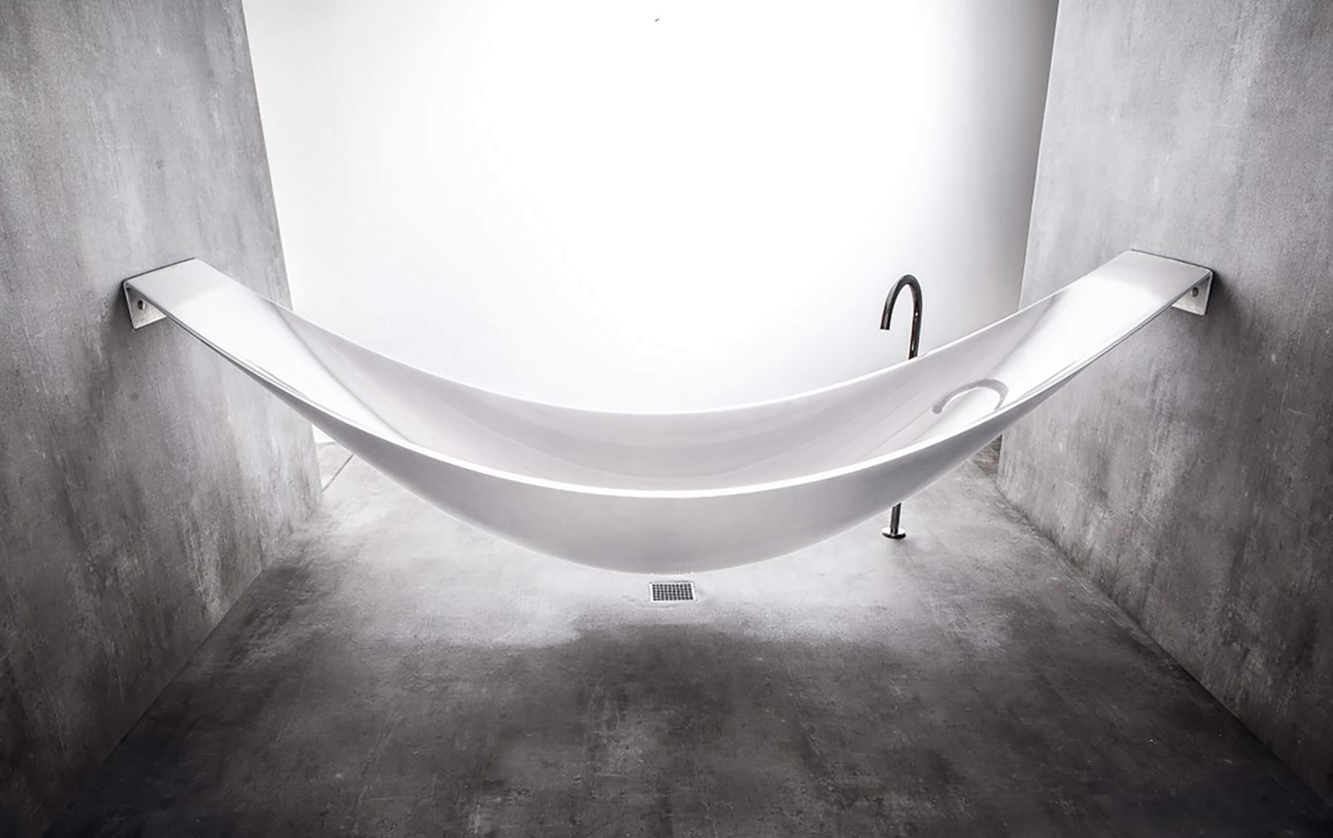 With hammock bath manufactured by Splinterworks in industrial concrete bathroom