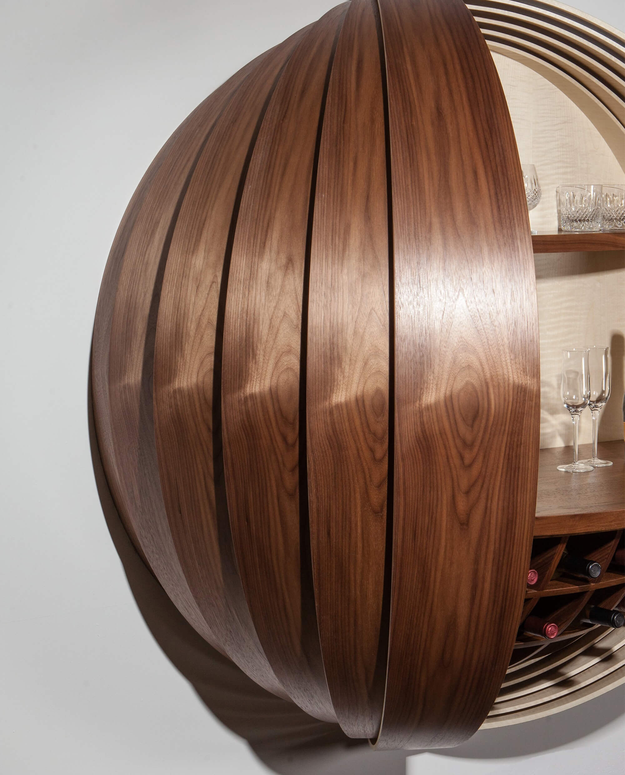 Spherical wall-mounted liquor cabinet with walnut finish.