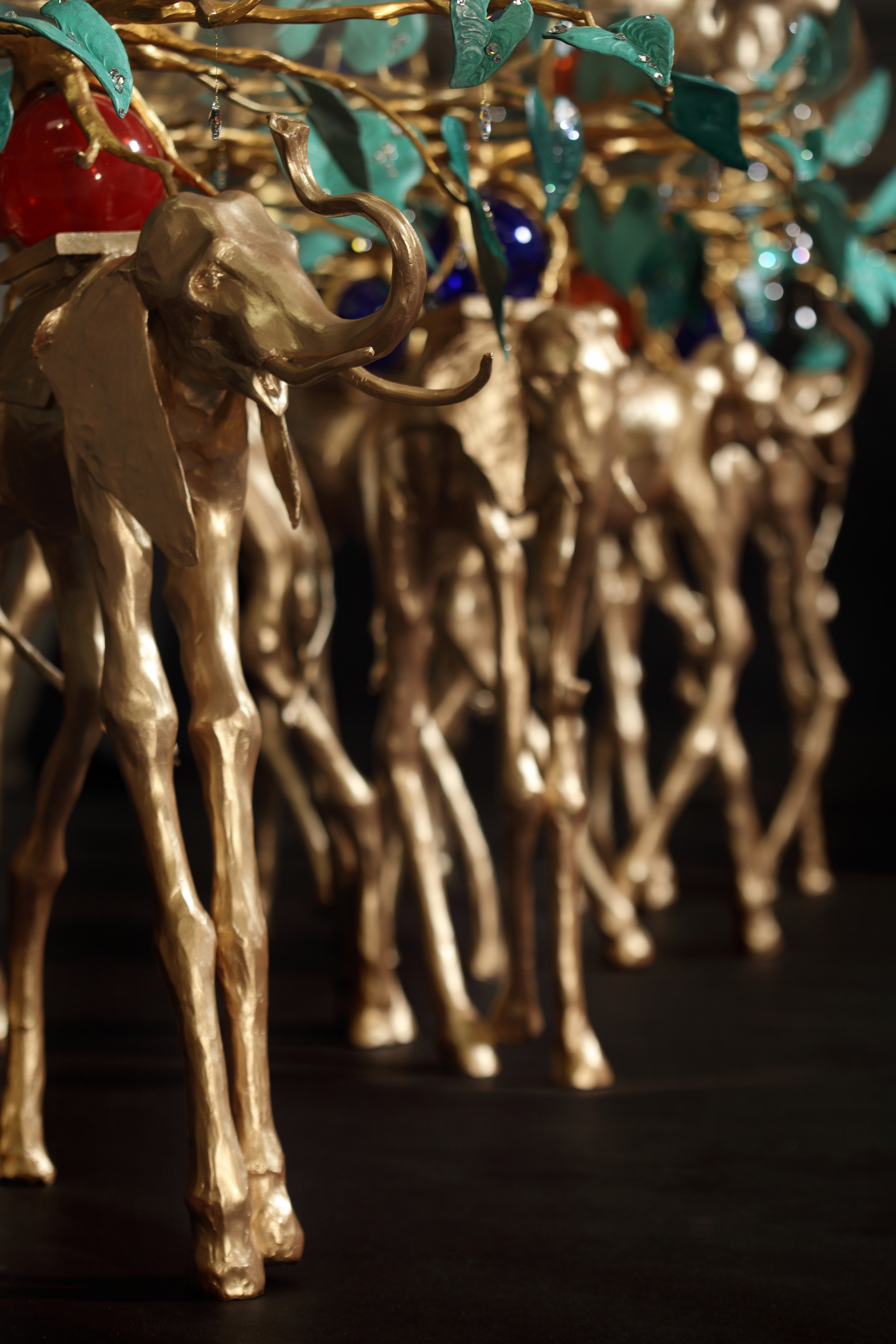 Detail of hand sculpted banquet table legs depicting surrealist elephants with jewels.