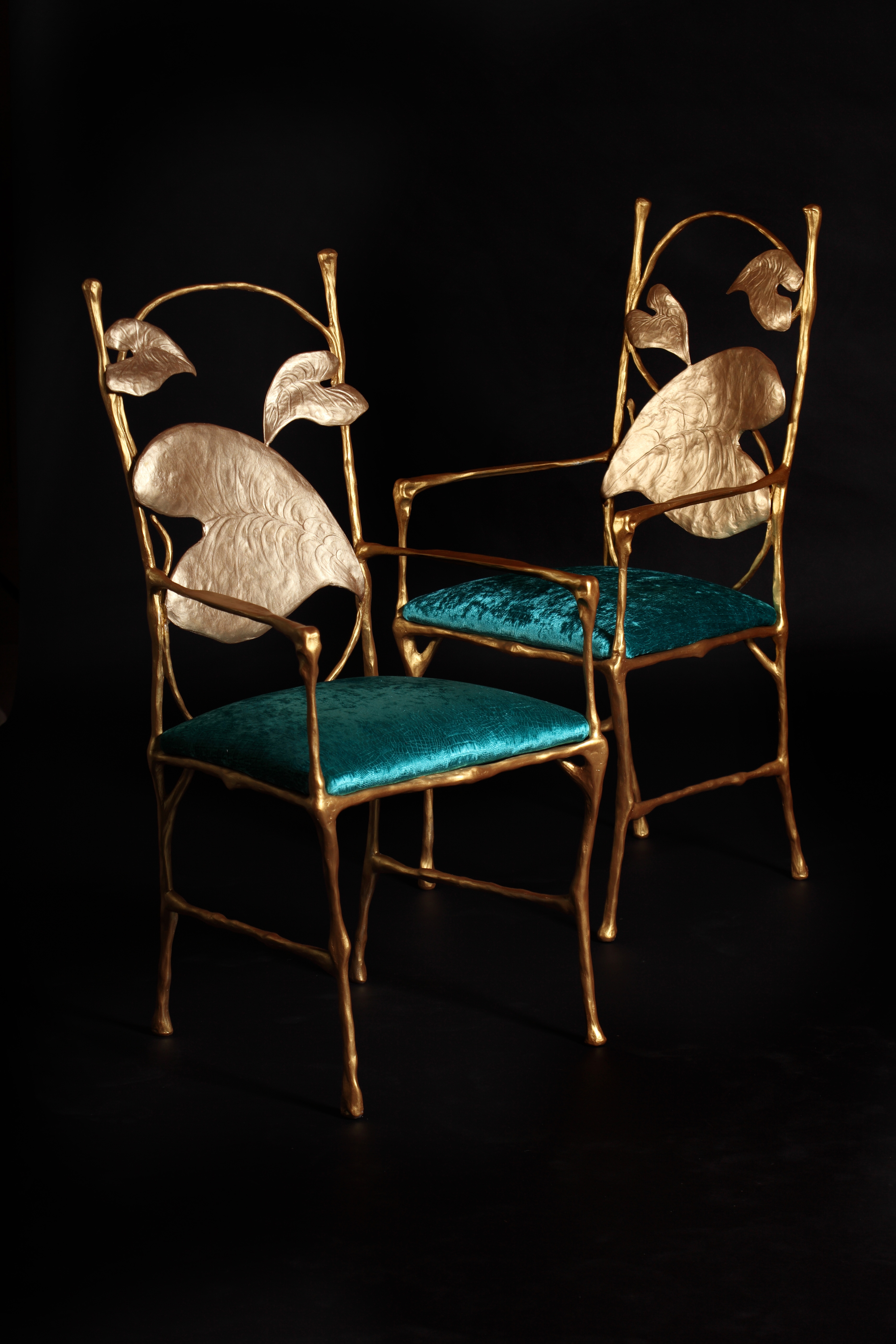 Hand sculpted bronze chairs with teal velvet seats are a bespoke furniture commission by Splinterworks