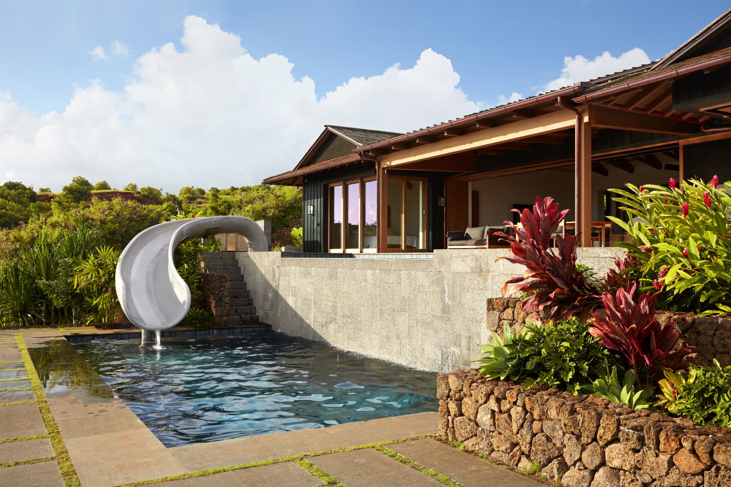 Concrete slide from top deck sweeping down into swimming pool in Hawaii