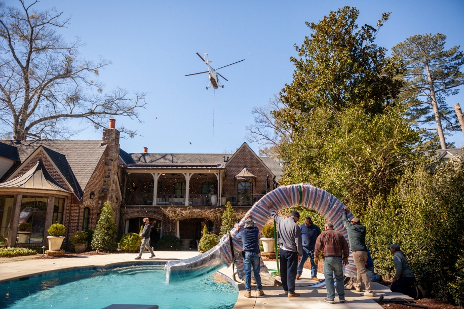 Helicopter flying over avproperty after placing slide next to pool