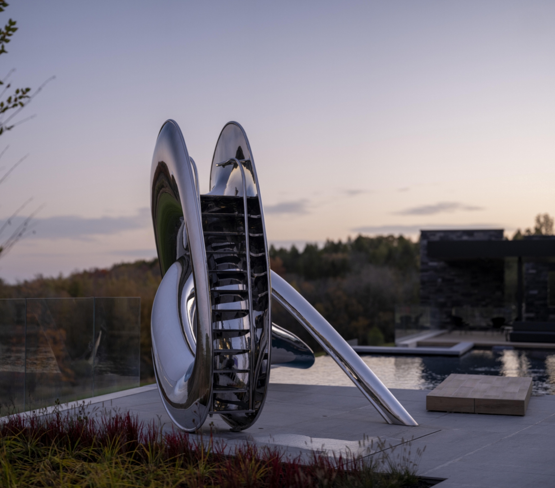 Steps of the Tryst pool slide, with the house in the background and foliage in the foreground