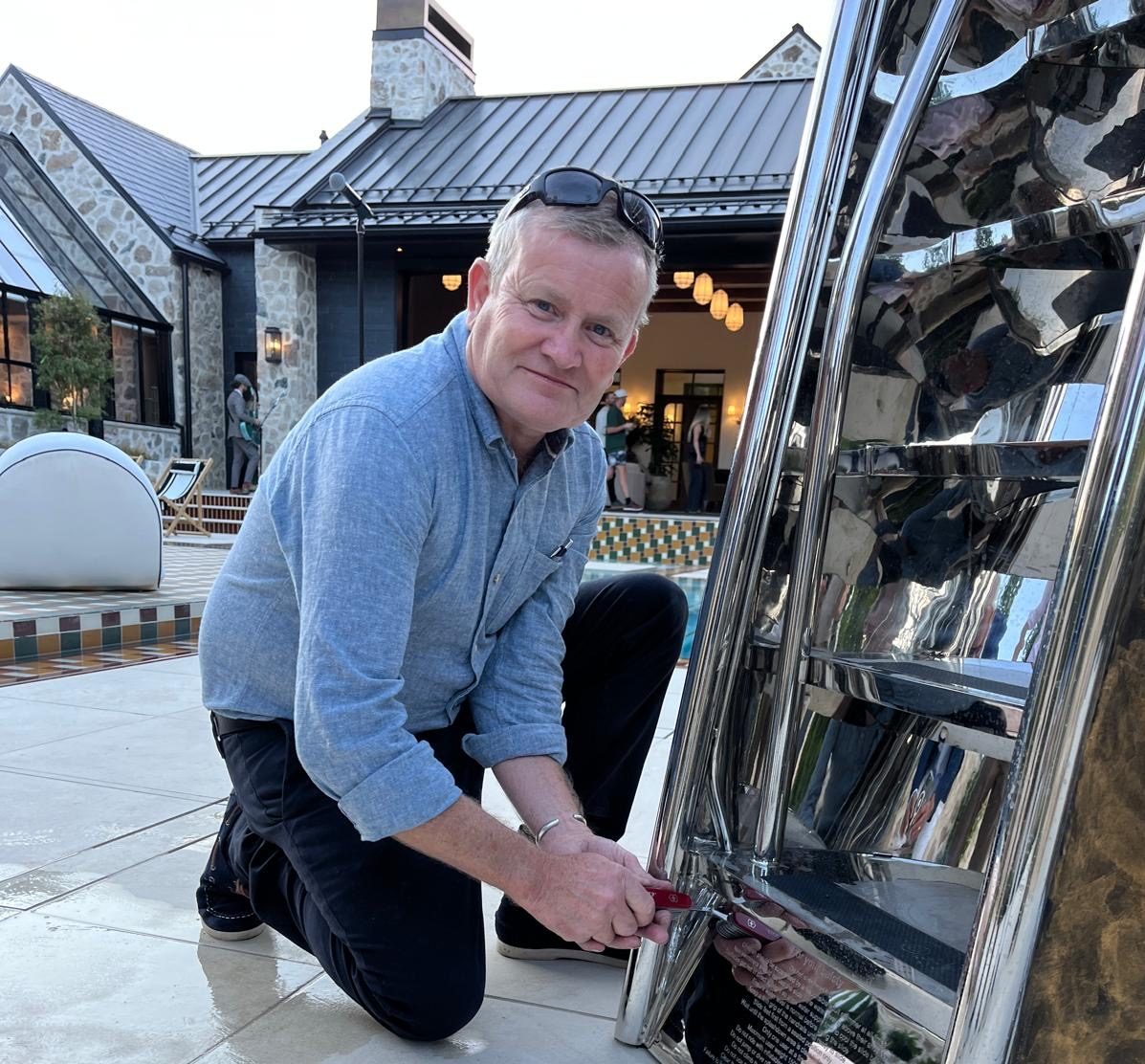 Professional installation of a Splinterworks luxury pool slide. Installations Manager John on-location at a modern estate to oversee the assembly and finishing of a bespoke stainless steel functional sculpture.